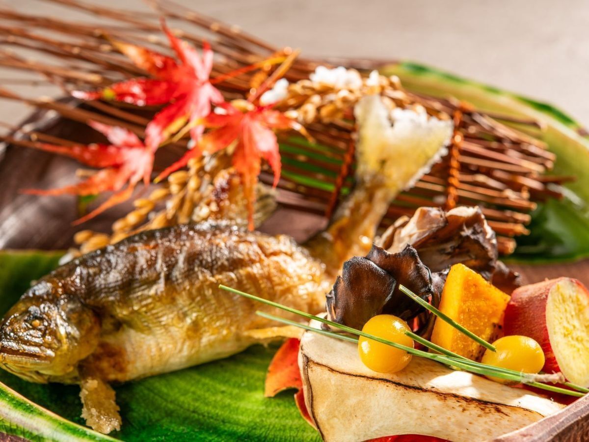 A fish dish with vegetables and garnishes on a plate.
