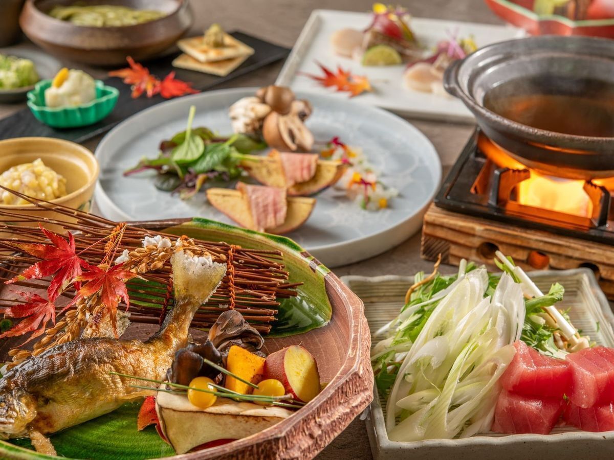 Una variedad de platos, incluyendo un pescado entero, verduras y una olla caliente.
