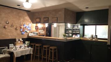 A bar area with stools, a counter, and a display of items on the wall.