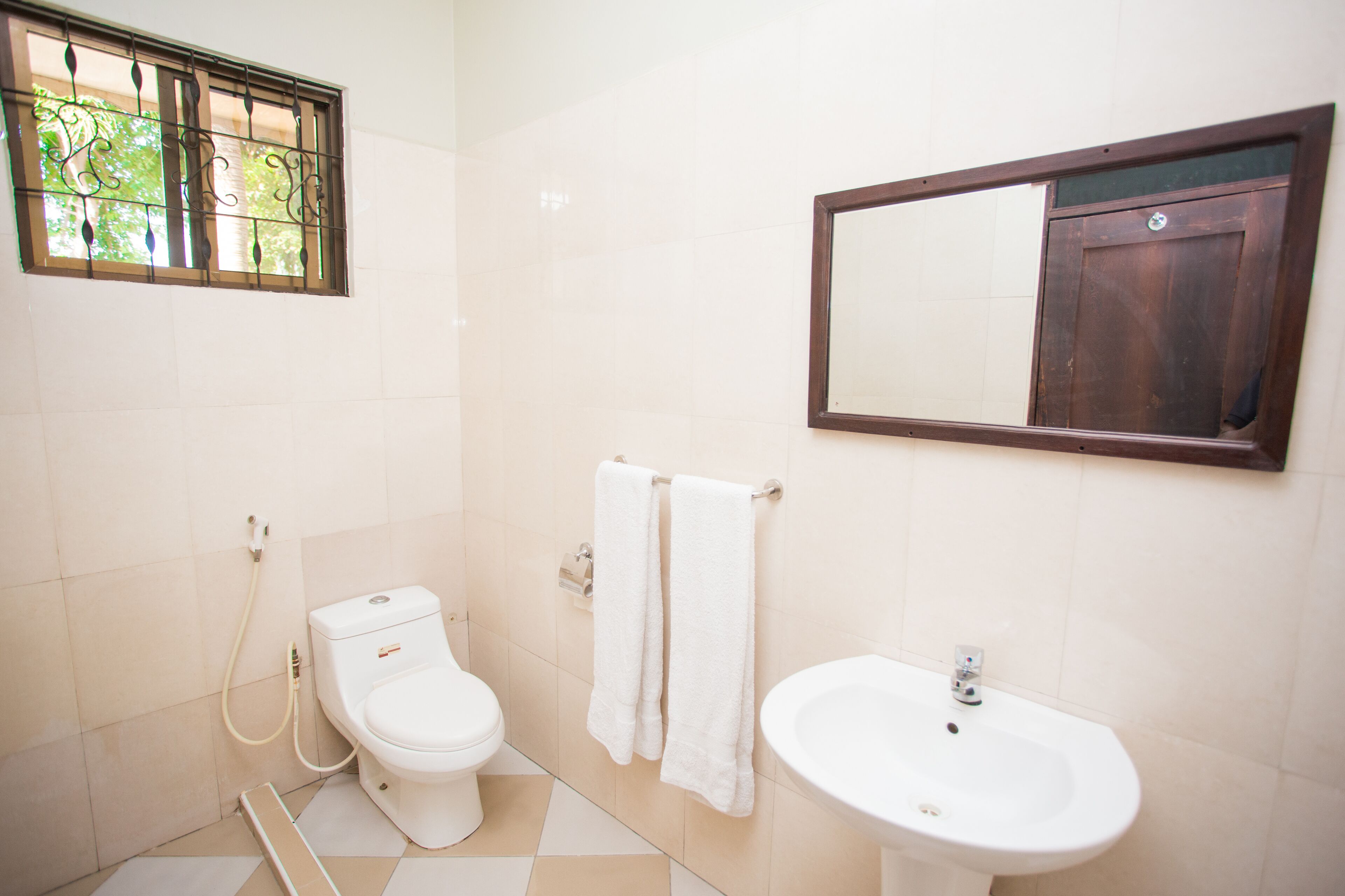 Une salle de bain avec des toilettes, un lavabo et un miroir.