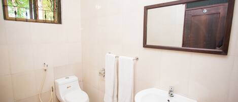 Une salle de bain avec des toilettes, un lavabo et un miroir.