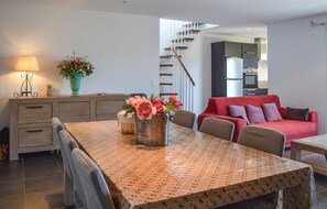 Enjoy meals together at the dining table, which seats four, surrounded by a comfortable sofa and chair.