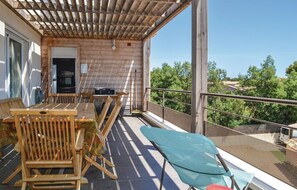 Enjoy a peaceful outdoor space with a table, chairs, and comfortable seating area overlooking lush surroundings.
