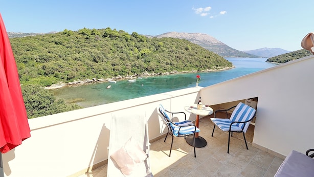 A balcony with a view of a lake, chairs, and a table. - Apartments Villa Cebalo Kor (Korcula)