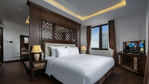 A spacious hotel room with a large bed, wooden headboard, and a television on a wooden cabinet. - The Q Hotel Hanoi (Hanoi)