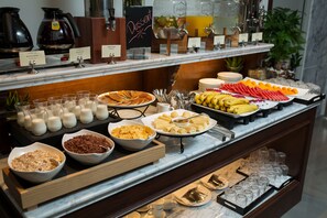 A buffet with various food items and beverages, including fruits, cereals, and coffee. - The Q Hotel Hanoi (Hanoi)