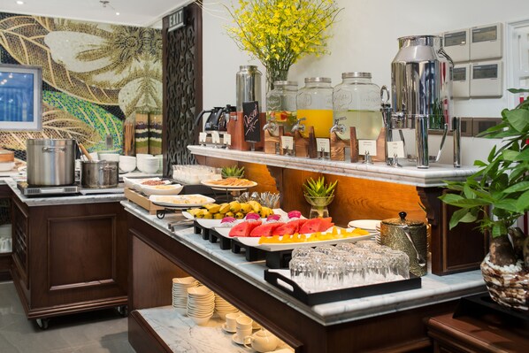 Un buffet proposant une variété de plats, un coin café et un mur décoratif.
