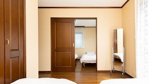 Ein Hotelzimmer mit zwei Betten, einem Schrank und einem Spiegel.