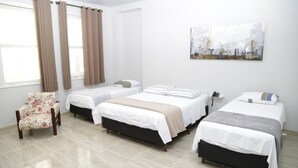 A hotel room with three beds, a chair, and a painting on the wall. - Hotel Pousada Cassino (Caete)