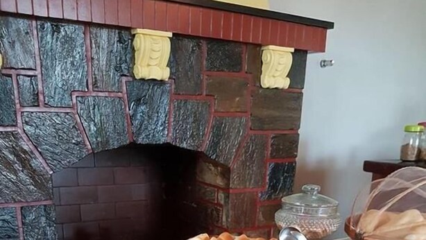 A buffet table with baskets of bread, rolls, and pastries. - Hotel Pousada Cassino (Caete)