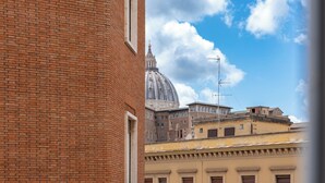 A view of a brick building with a large dome in the background. - Domus Porta Angelica (Rome)