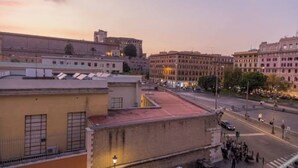 A cityscape with buildings, a street, and a group of people. - Domus Porta Angelica (Rome)