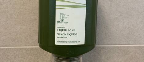 Een fles Pure Herbs vloeibare zeep met een etiket dat aangeeft dat het aromatisch is en rozemarijn, citroenmelisse en tijm bevat.