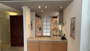 Una cucina moderna con isola centrale, elettrodomestici integrati e luci a sospensione.