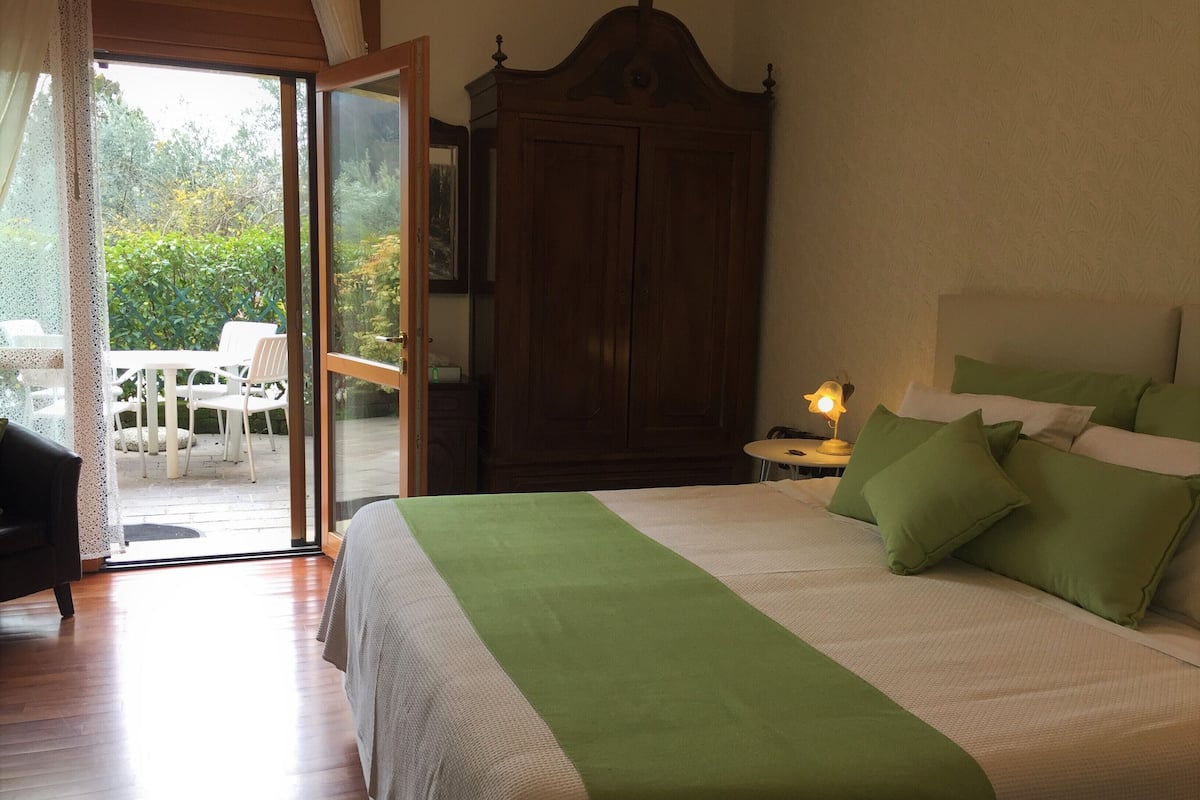 Une chambre à coucher avec un grand lit, une armoire en bois et une table avec une lampe.