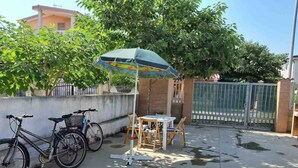 A patio area with a table and chairs, a bicycle, and an umbrella.