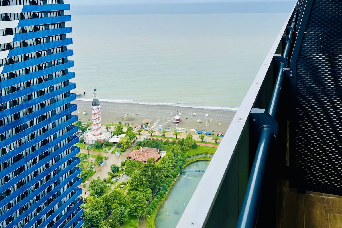 Een hoog gebouw met uitzicht op een strand en een rivier.
