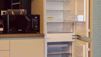 Una cocina con microondas, tostadora y refrigerador.
