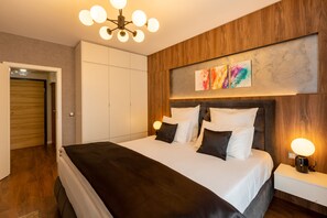 Un dormitorio moderno con una cama grande, paneles de madera, una lámpara en el techo y una obra de arte en la pared.