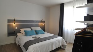 Un dormitorio moderno con cama, mesitas de noche y armario.