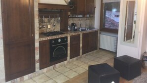Eine kleine Küche mit Holzausstattung, einem integrierten Backofen und einem Fenster für natürliches Licht.