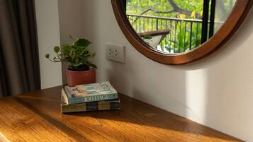 A wooden table with a potted plant and two books.