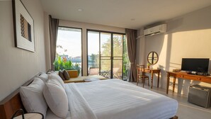 A bedroom with a large bed, a desk, a chair, and a television. - Ploen Pirom (Bangkok)