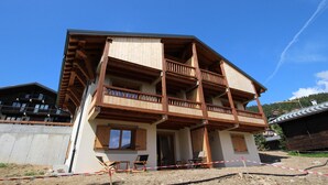 A two-story building with wooden balconies and a covered porch area. - New apartment 6 ppl Les Saisies, terrace, parking (Hauteluce)