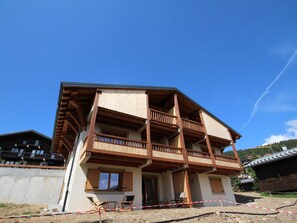A two-story building with wooden balconies and a covered porch area.