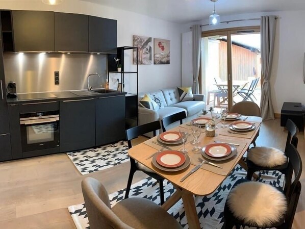 Enjoy a meal at the dining table, surrounded by a comfortable living area with a sofa and chairs.