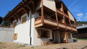A two-story wooden house with a balcony on the second floor. - New apartment 6 ppl Les Saisies, terrace, parking (Hauteluce)