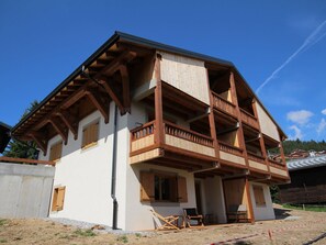 A two-story wooden house with a balcony on the second floor.