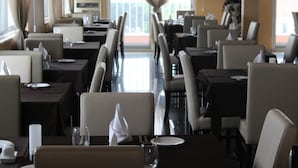 Un restaurante con un diseño alargado y estrecho, con filas de mesas y sillas.
