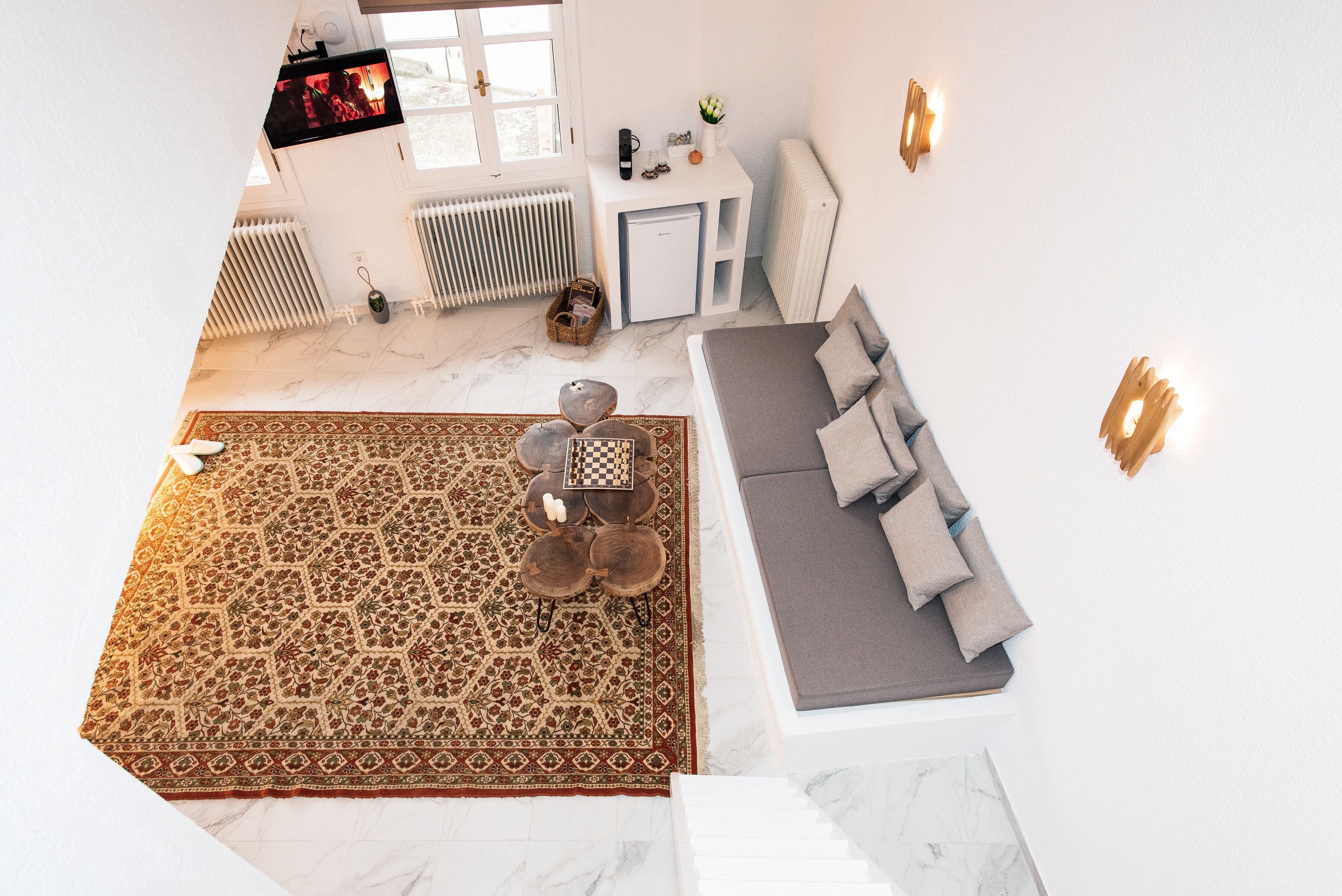A modern living room with a sofa, a coffee table, a rug, and a television.