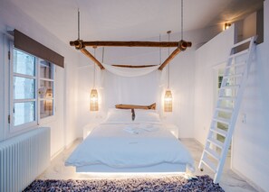 A bedroom with a bed, bedside lamps, a ladder, and a window. - Blue Mountain Guesthouse Arachova (Distomo-Arachova-Antikyra)