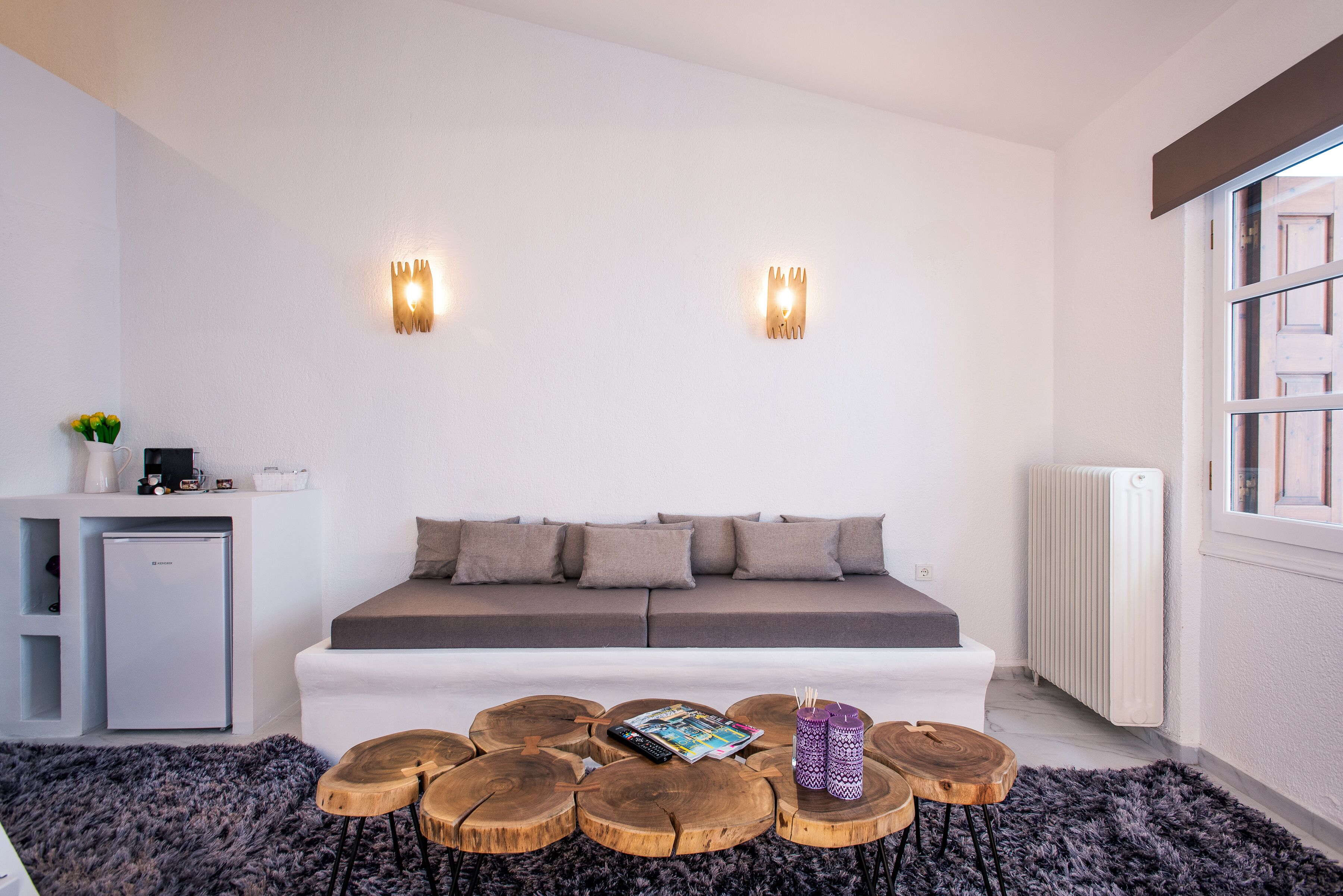 A modern living room with a sofa, coffee table, and wall-mounted lights.