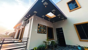 Un edificio moderno con techo inclinado, tragaluz y balcón con plantas en macetas.