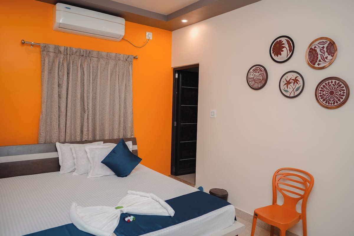 A hotel room with a bed, a chair, and wall decorations.