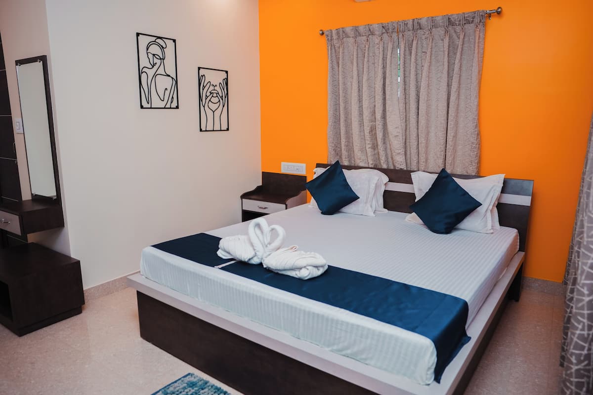 A modern hotel room with a large bed, a bedside table, a nightstand, and a mirror.
