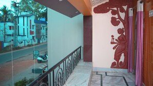 Un pasillo de hotel con suelo de mármol, un mural decorativo y vistas a la calle.