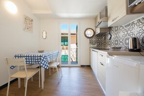 A kitchen with a dining table, chairs, a toaster, and a dishwasher.
