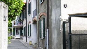 A narrow street with buildings featuring arched windows and shutters. - JOIVY Little House (Como)