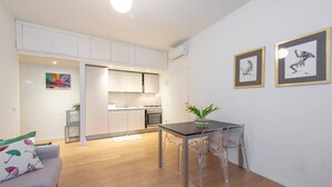 A modern apartment with a dining area, kitchen, and living space. - JOIVY Apartment, Window to the Vertical Forest (Milan)