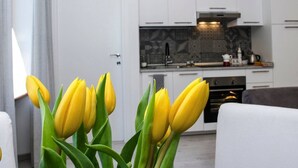 Una cocina moderna con armarios blancos, un salpicadero estampado y un horno empotrado.