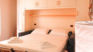 A single bed with a white mattress and pillows, a wooden headboard, and a white wardrobe with two doors. - JOIVY Riva Trigoso Casetta nel Borgo (Sestri Levante)