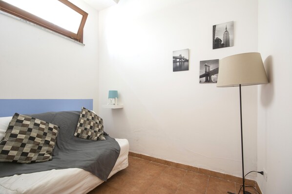 Une chambre à coucher avec un lit, des oreillers, une lampe et des œuvres d’art murales.