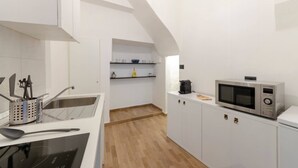 A modern kitchen with white cabinetry, a microwave, and a coffee maker. - JOIVY Porto Bello a Camogli (Camogli)
