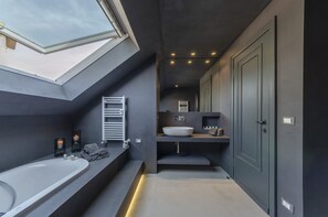 Enjoy a relaxing soak in the bathtub or freshen up at the large vessel sink.