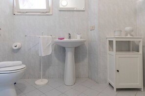 A bathroom with a toilet, sink, and cabinet. - JOIVY Villa Il Glicine sul Mare (Pietrasanta)