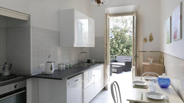Una cocina compacta con comedor, horno integrado y vista a un espacio de estar exterior.